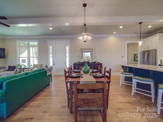 dining space with crown molding, light hardwood / wood-style flooring, and ceiling fan