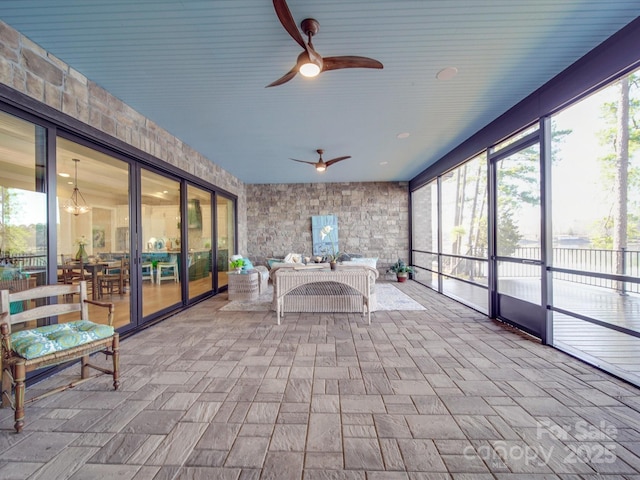 unfurnished sunroom featuring ceiling fan