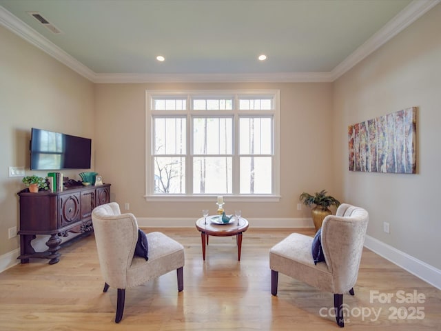 sitting room featuring crown molding and light wood-type flooring