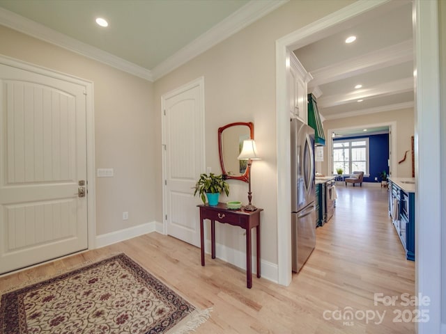 foyer entrance with ornamental molding and light hardwood / wood-style floors