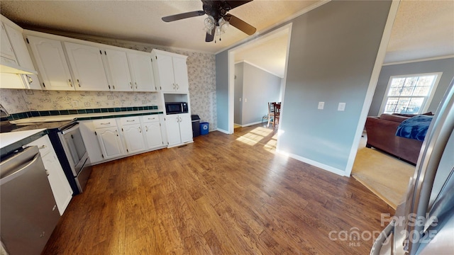 kitchen with crown molding, light hardwood / wood-style floors, white cabinets, and appliances with stainless steel finishes