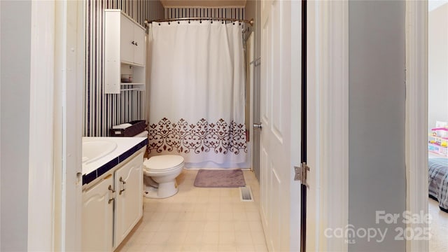 bathroom featuring vanity, a shower with shower curtain, and toilet