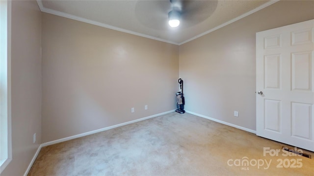 carpeted spare room featuring crown molding and ceiling fan