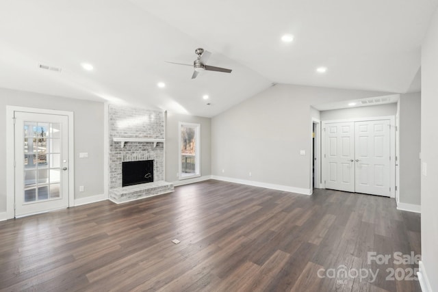 unfurnished living room featuring lofted ceiling, a brick fireplace, dark hardwood / wood-style floors, and ceiling fan