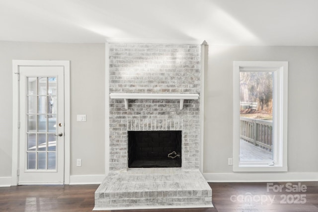 living room with dark hardwood / wood-style flooring and a brick fireplace