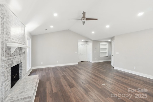 unfurnished living room featuring vaulted ceiling, a brick fireplace, ceiling fan, and dark hardwood / wood-style flooring