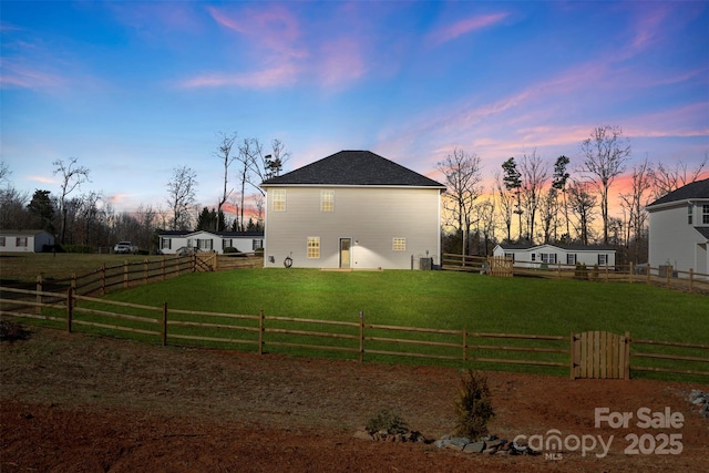 property exterior at dusk with a lawn