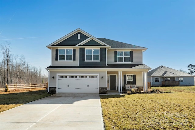 view of front of property featuring a garage, a front yard, and covered porch