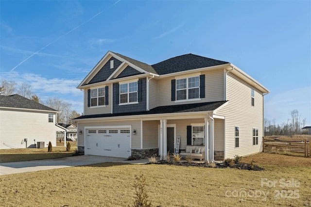 craftsman-style home with a garage, covered porch, and a front lawn