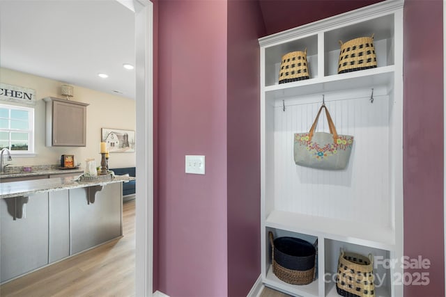 mudroom with sink and light wood-type flooring