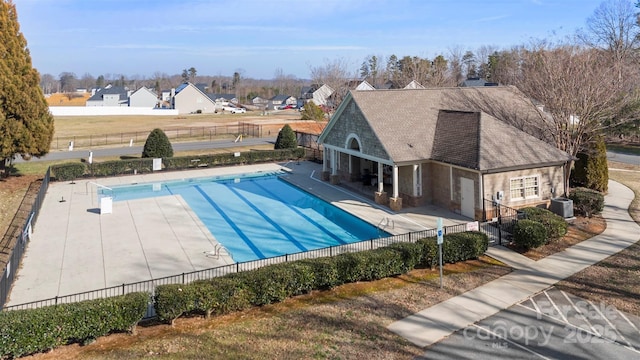 view of pool with cooling unit and a patio