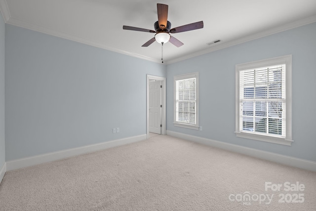 empty room with light carpet, ceiling fan, crown molding, and a healthy amount of sunlight