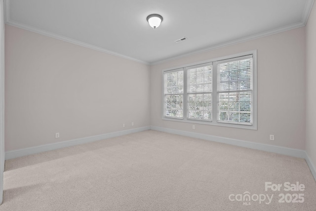 empty room with crown molding and light colored carpet