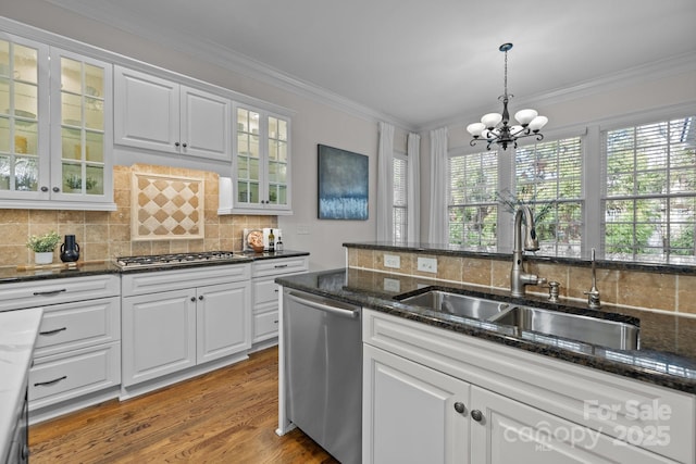 kitchen featuring white cabinetry, appliances with stainless steel finishes, sink, and dark stone counters