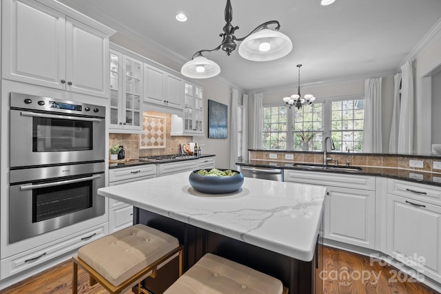 kitchen featuring sink, a breakfast bar area, a center island, dark stone countertops, and stainless steel appliances