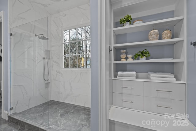 bathroom featuring tiled shower and built in shelves