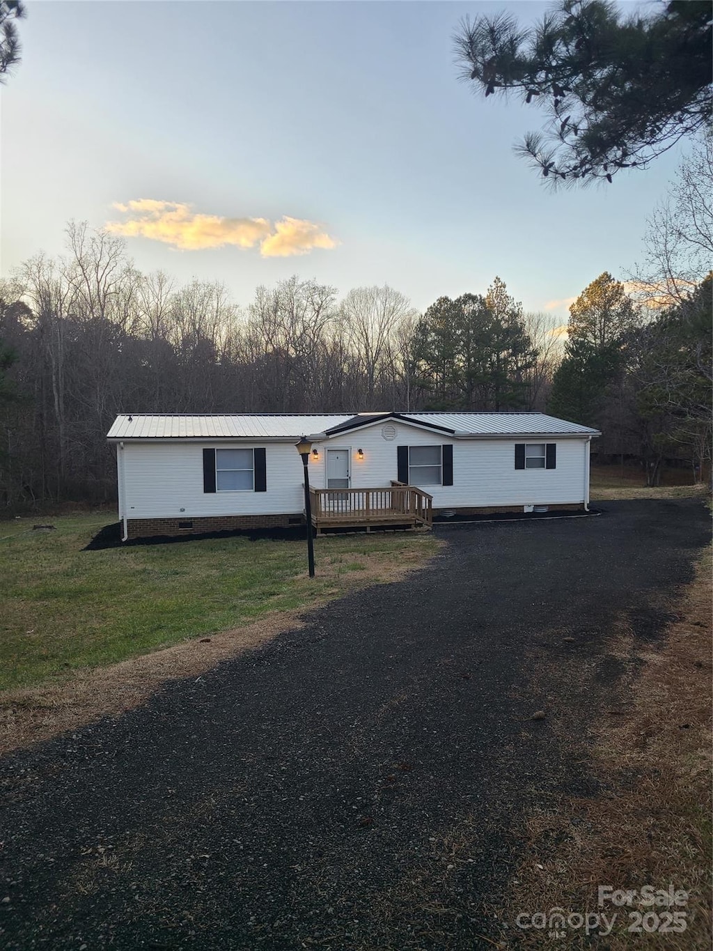 view of front of home featuring a wooden deck and a yard