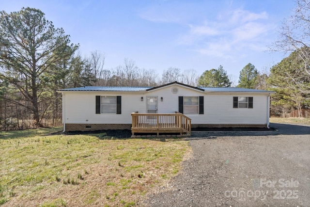 manufactured / mobile home with a deck and a front lawn