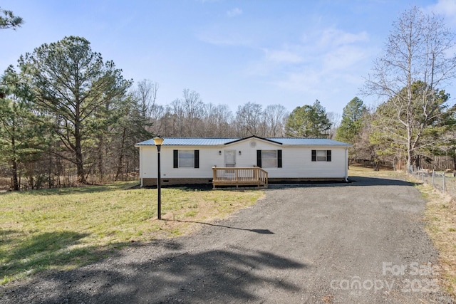 manufactured / mobile home featuring a wooden deck and a front yard