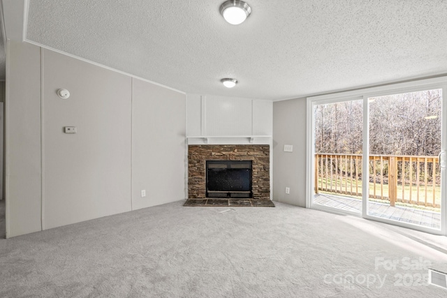 unfurnished living room with a fireplace, carpet floors, and a textured ceiling