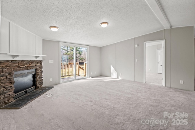 unfurnished living room with carpet floors, a textured ceiling, and a fireplace