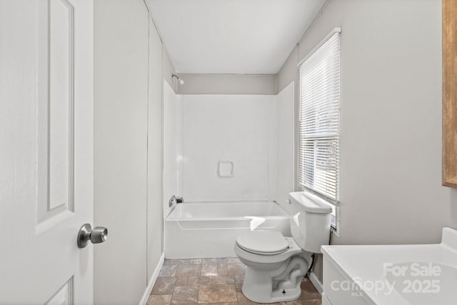 bathroom featuring tub / shower combination and toilet