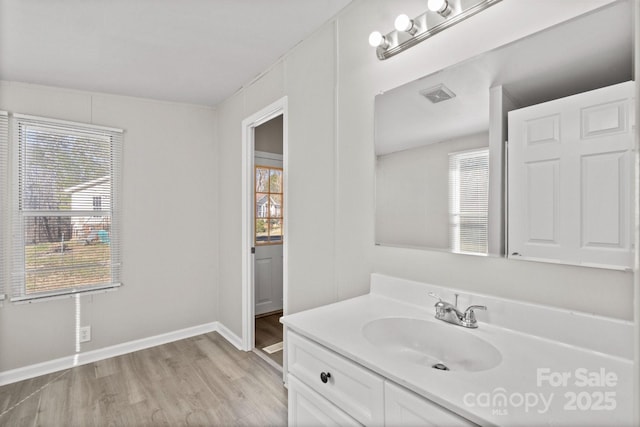 bathroom with vanity, a healthy amount of sunlight, and hardwood / wood-style floors