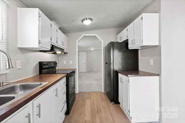 kitchen featuring white cabinets, sink, light hardwood / wood-style flooring, and black appliances