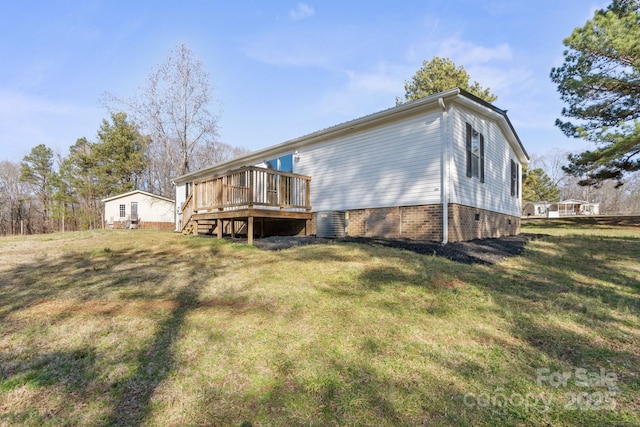 back of house with a wooden deck and a lawn