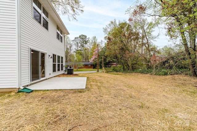 view of yard with central air condition unit and a patio area