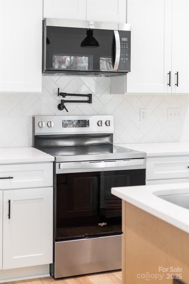 kitchen featuring white cabinets, tasteful backsplash, and appliances with stainless steel finishes