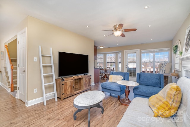 living room featuring ceiling fan and light hardwood / wood-style flooring