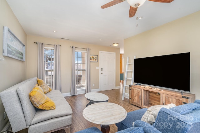 living room with wood-type flooring and ceiling fan