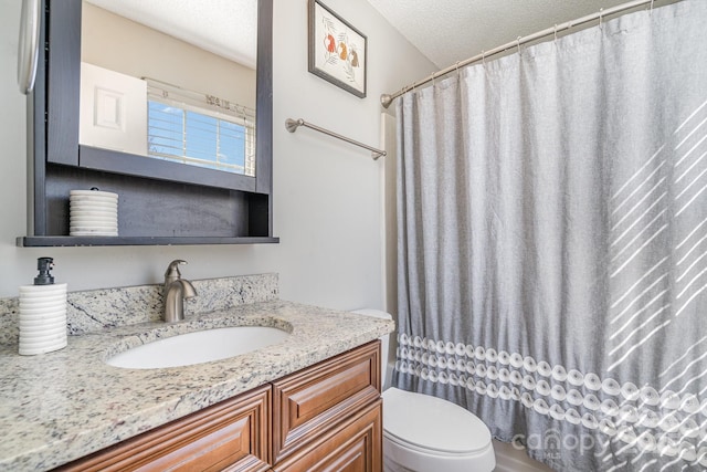 bathroom featuring vanity, a textured ceiling, and toilet