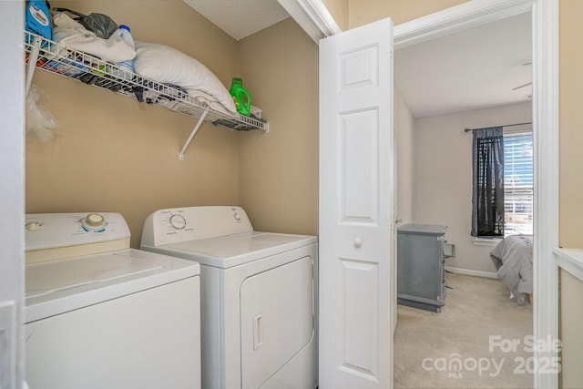 clothes washing area featuring light carpet and washer and clothes dryer