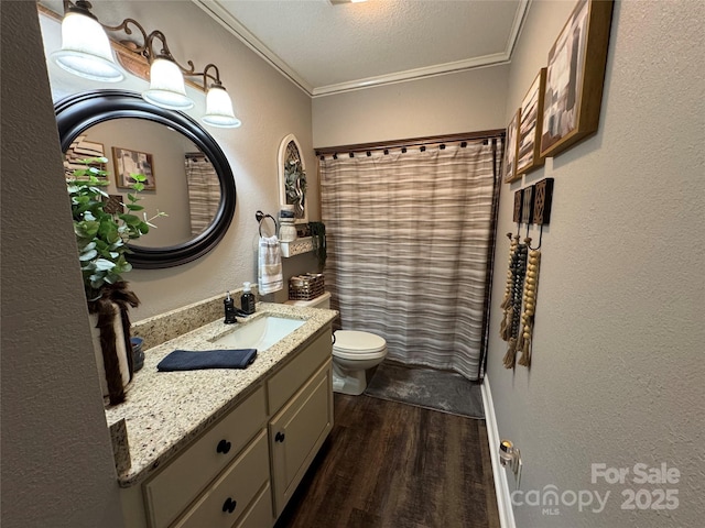 bathroom with crown molding, hardwood / wood-style floors, vanity, a textured ceiling, and toilet