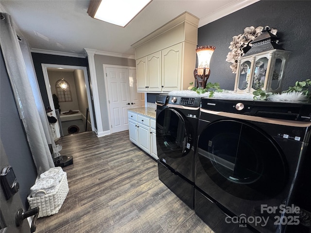 washroom featuring cabinets, ornamental molding, hardwood / wood-style flooring, and washing machine and clothes dryer