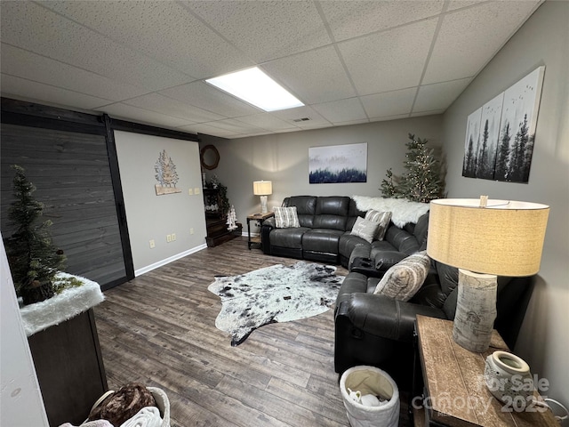 living room featuring wood-type flooring and a paneled ceiling