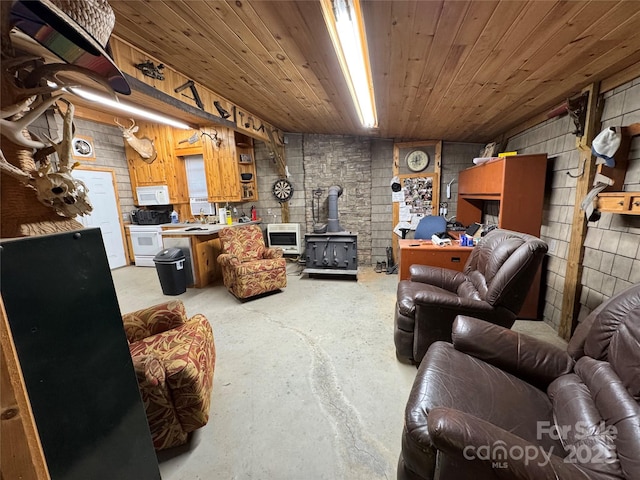 living room featuring concrete flooring, a wood stove, heating unit, and wooden ceiling