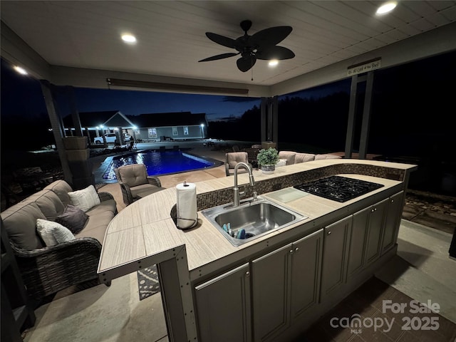 view of patio / terrace featuring sink, ceiling fan, and an outdoor kitchen