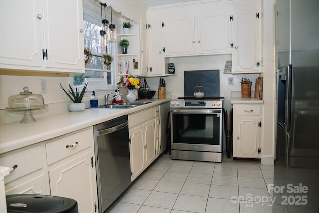 kitchen with light tile patterned flooring, sink, decorative light fixtures, appliances with stainless steel finishes, and white cabinets