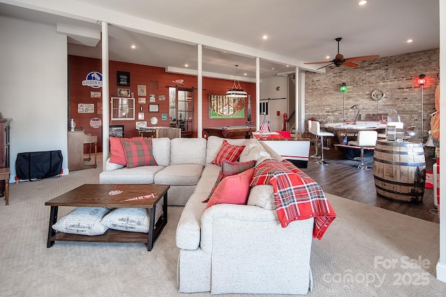 living room with hardwood / wood-style floors, pool table, ceiling fan, and brick wall