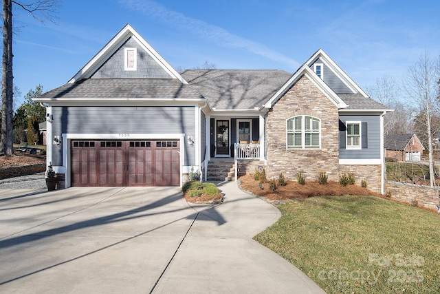 craftsman house with a garage, a front yard, and covered porch