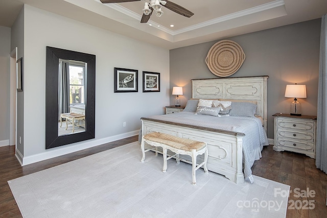 bedroom with ceiling fan, ornamental molding, wood-type flooring, and a tray ceiling