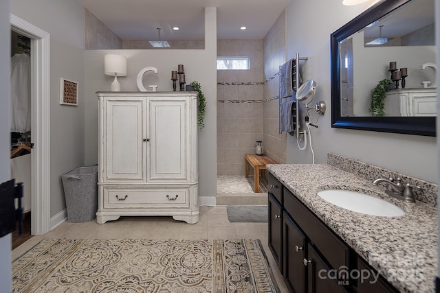 bathroom featuring vanity, a tile shower, and tile patterned floors