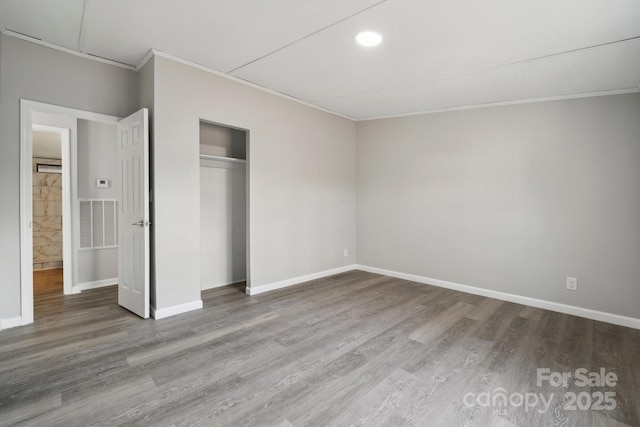 unfurnished bedroom featuring ornamental molding, hardwood / wood-style floors, and a closet