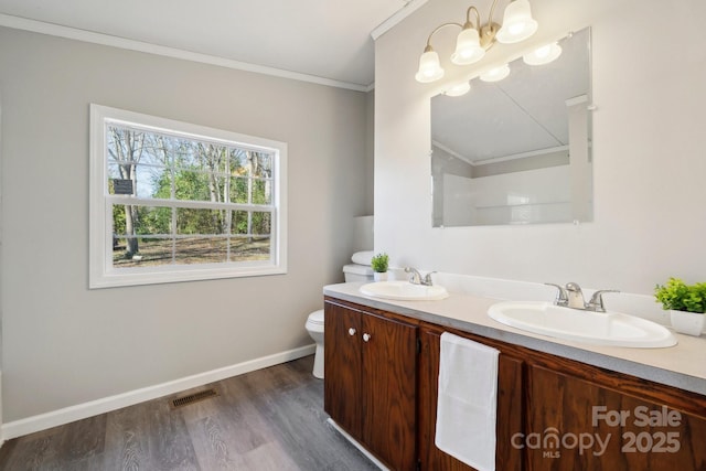 bathroom featuring crown molding, wood-type flooring, vanity, and toilet