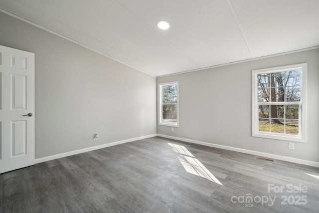 empty room featuring dark hardwood / wood-style flooring and vaulted ceiling