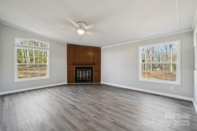 unfurnished living room with hardwood / wood-style flooring, ornamental molding, and a fireplace