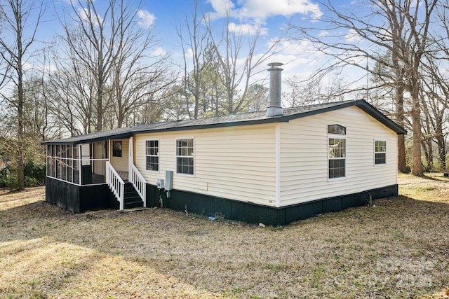 view of front facade with a sunroom and a front lawn